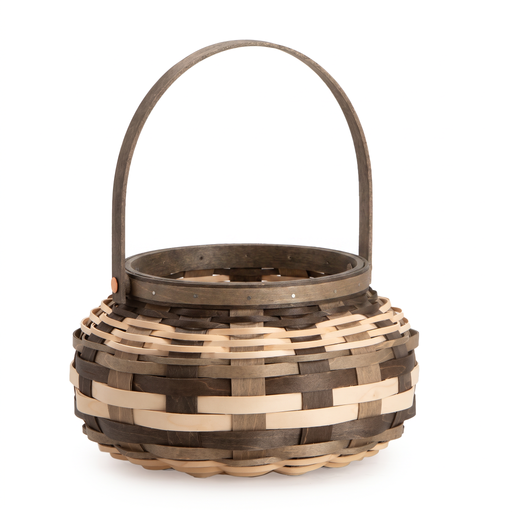 A small woven basket with a rounded body, alternating dark brown and light natural wood strips, and a single arched handle on a white background.