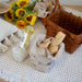 Bottle of white wine, bread, and sunflowers on a table with a woven basket.