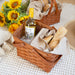 Picnic basket with wine, bread, and sunflowers on a textured surface